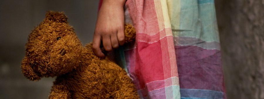 Cropped view of a little girl holding a teddy bear